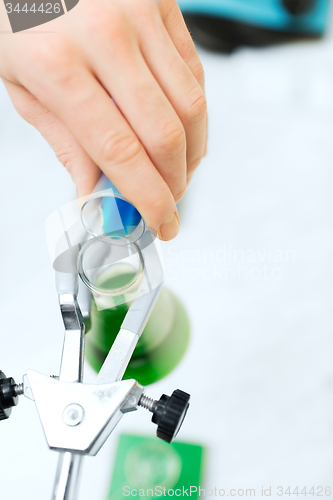 Image of close up of scientist filling test tubes in lab