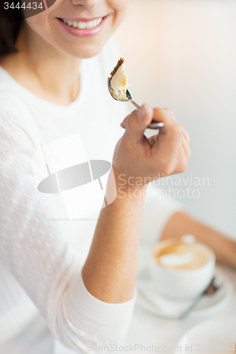 Image of close up of woman eating cake at cafe or home