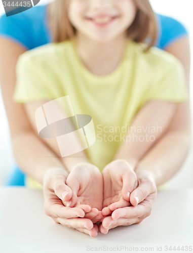 Image of close up of woman and girl with cupped hands