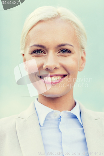 Image of young smiling businesswoman over office building