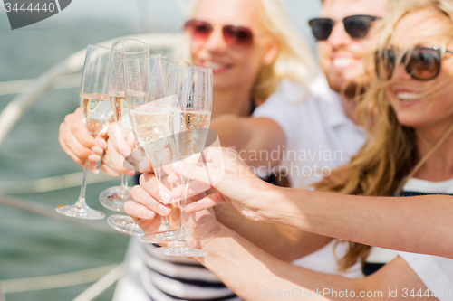 Image of happy friends with glasses of champagne on yacht