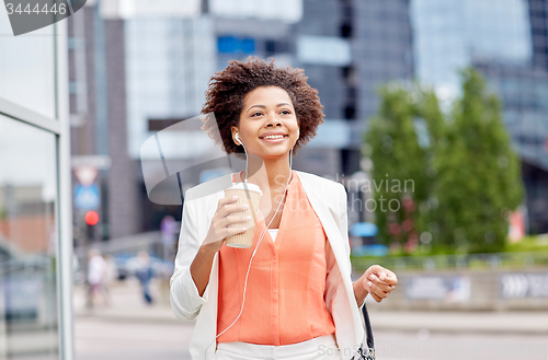 Image of happy african businesswoman with coffee in city