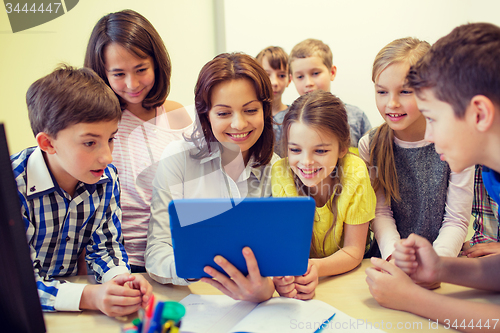 Image of group of kids with teacher and tablet pc at school