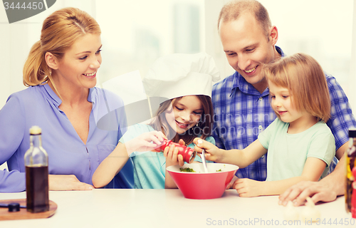 Image of happy family with two kids making dinner at home