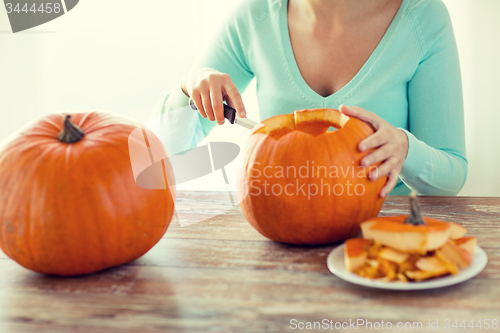 Image of close up of woman with pumpkins at home