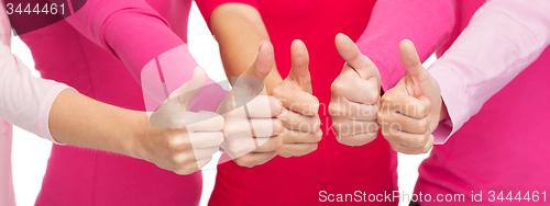 Image of close up of women in pink shirts showing thumbs up