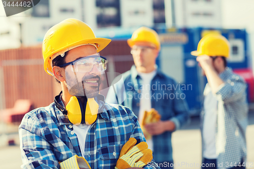 Image of group of smiling builders in hardhats outdoors