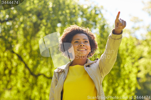 Image of happy african american young woman in summer park