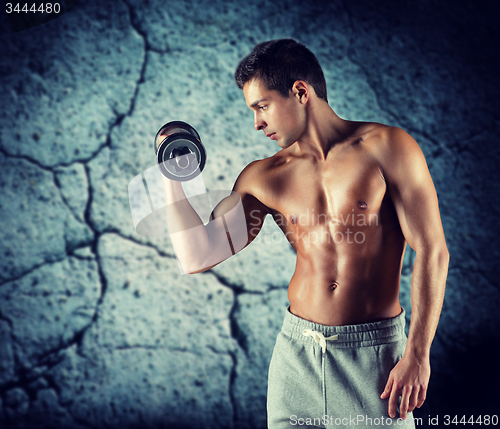 Image of young man with dumbbell flexing biceps