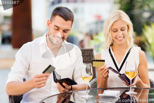 Image of couple with credit cards paying bill at restaurant