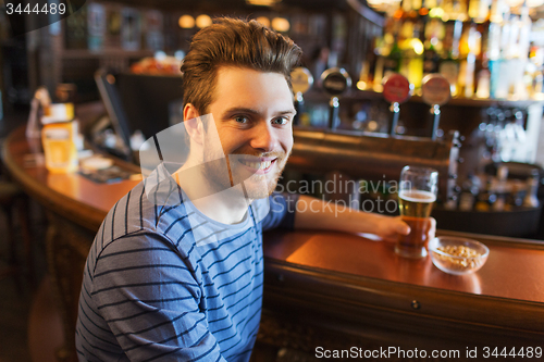 Image of happy man drinking beer at bar or pub