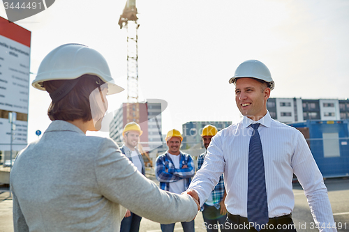 Image of builders making handshake on construction site