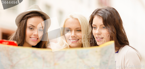 Image of beautiful girls looking into tourist map in city