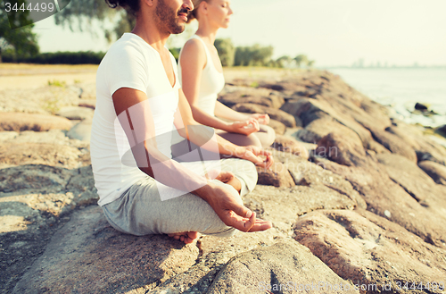 Image of close up of couple making yoga exercises outdoors