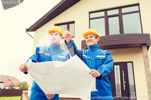 Image of group of builders with blueprint pointing finger