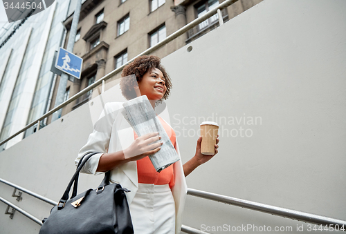 Image of happy african businesswoman with coffee in city