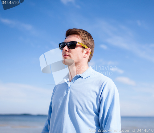 Image of young man in sunglasses at summer beach