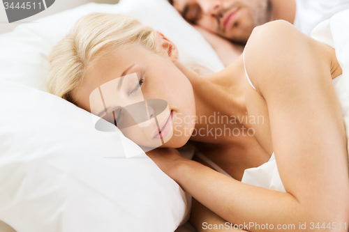 Image of happy couple sleeping in bed at home