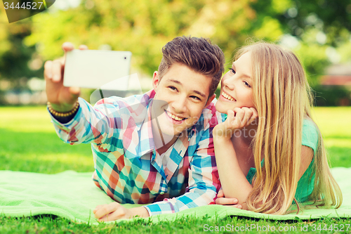 Image of smiling couple making selfie in park