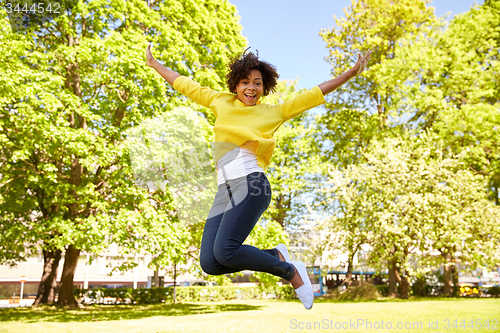 Image of happy african american young woman in summer park