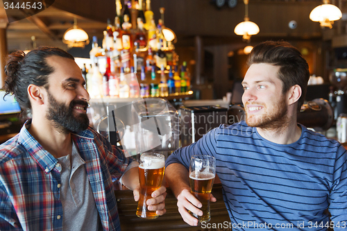 Image of happy male friends drinking beer at bar or pub