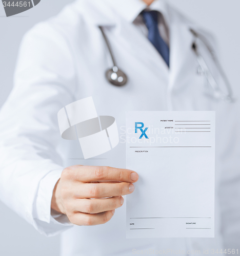 Image of male doctor holding rx paper in hand