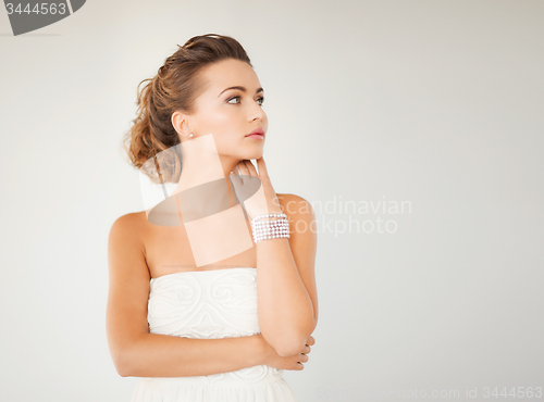 Image of woman with pearl earrings and bracelet