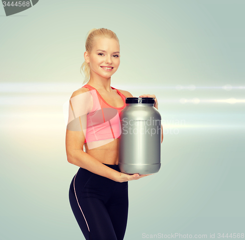 Image of smiling sporty woman with jar of protein