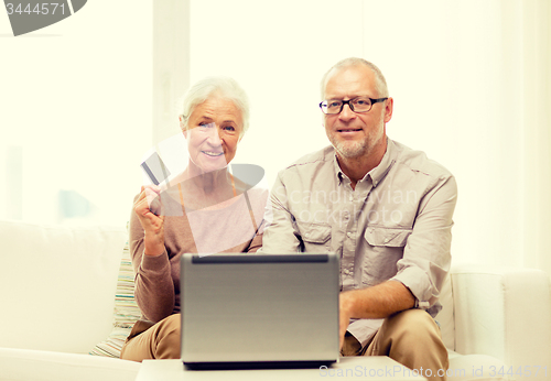 Image of happy senior couple with laptop and credit card