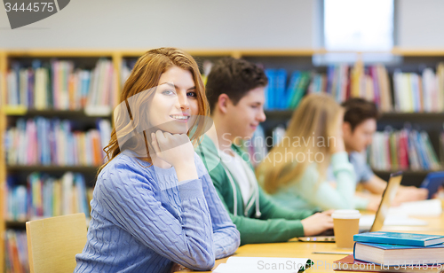 Image of happy student girl reading books in library