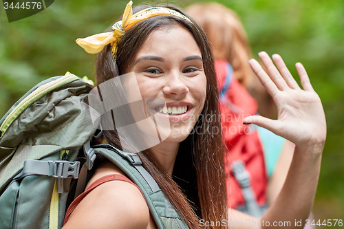 Image of group of smiling friends with backpacks hiking