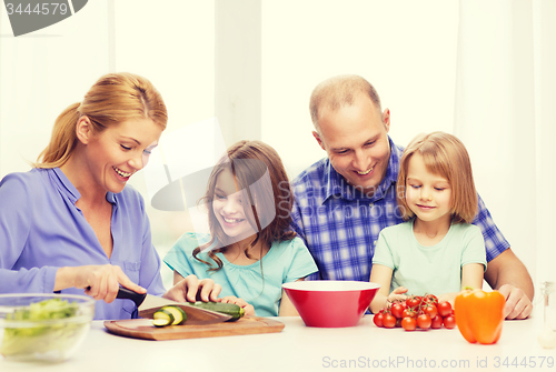 Image of happy family with two kids making dinner at home