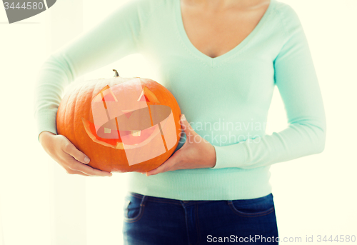 Image of close up of woman with pumpkins at home