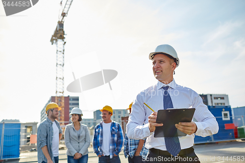 Image of happy builders and architect at construction site