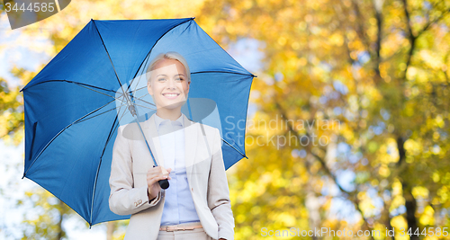 Image of businesswoman with umbrella over autumn background