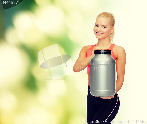 Image of smiling sporty woman with jar of protein