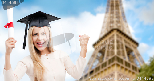 Image of student in trencher with diploma over eiffel tower