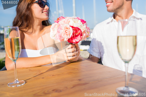 Image of smiling couple drinking champagne at cafe