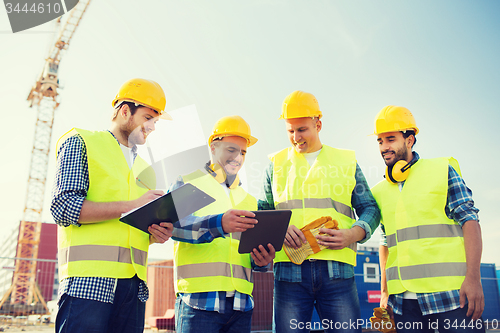 Image of group of smiling builders with tablet pc outdoors