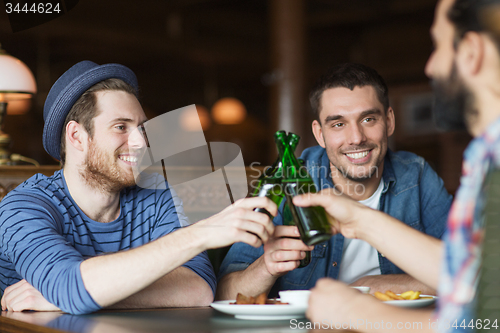 Image of happy male friends drinking beer at bar or pub