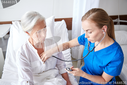 Image of nurse with stethoscope and senior woman at clinic