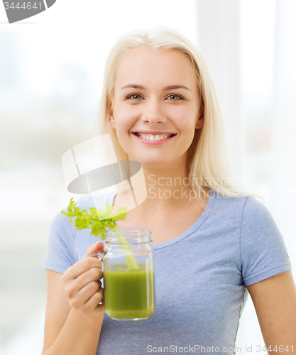 Image of smiling woman drinking juice or shake at home