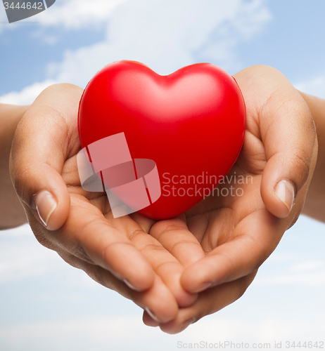 Image of womans cupped hands showing red heart