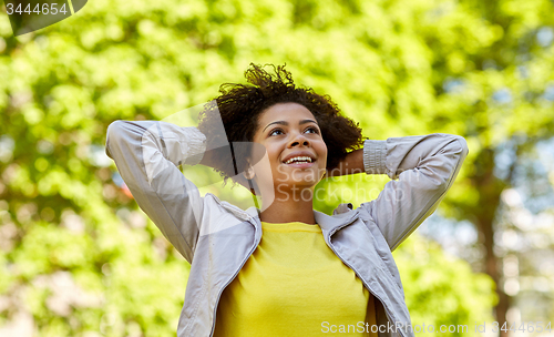 Image of happy african american young woman in summer park