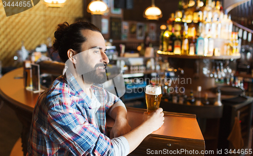 Image of happy man drinking beer at bar or pub