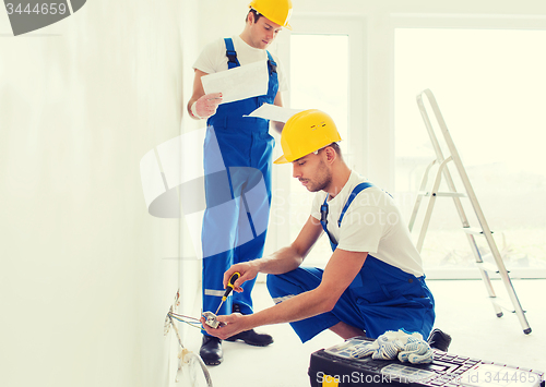 Image of builders with tablet pc and equipment indoors