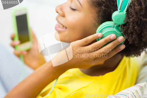 Image of happy african woman with smartphone and headphones