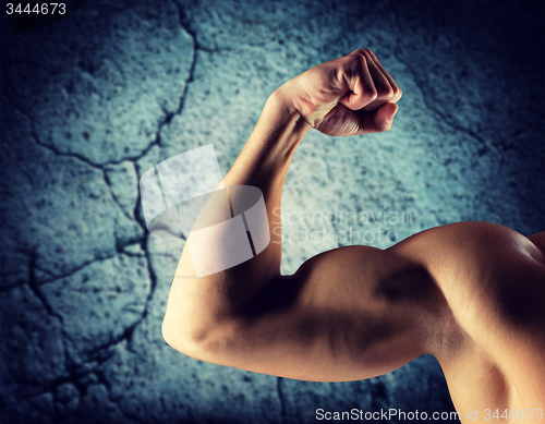 Image of close up of young man flexing and showing biceps