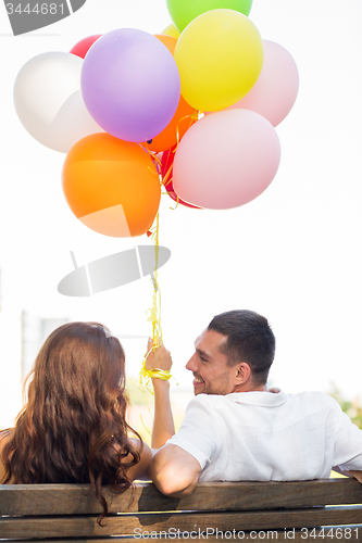 Image of happy couple with air balloons in city