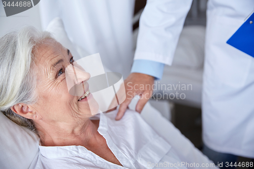 Image of doctor visiting happy senior woman at hospital